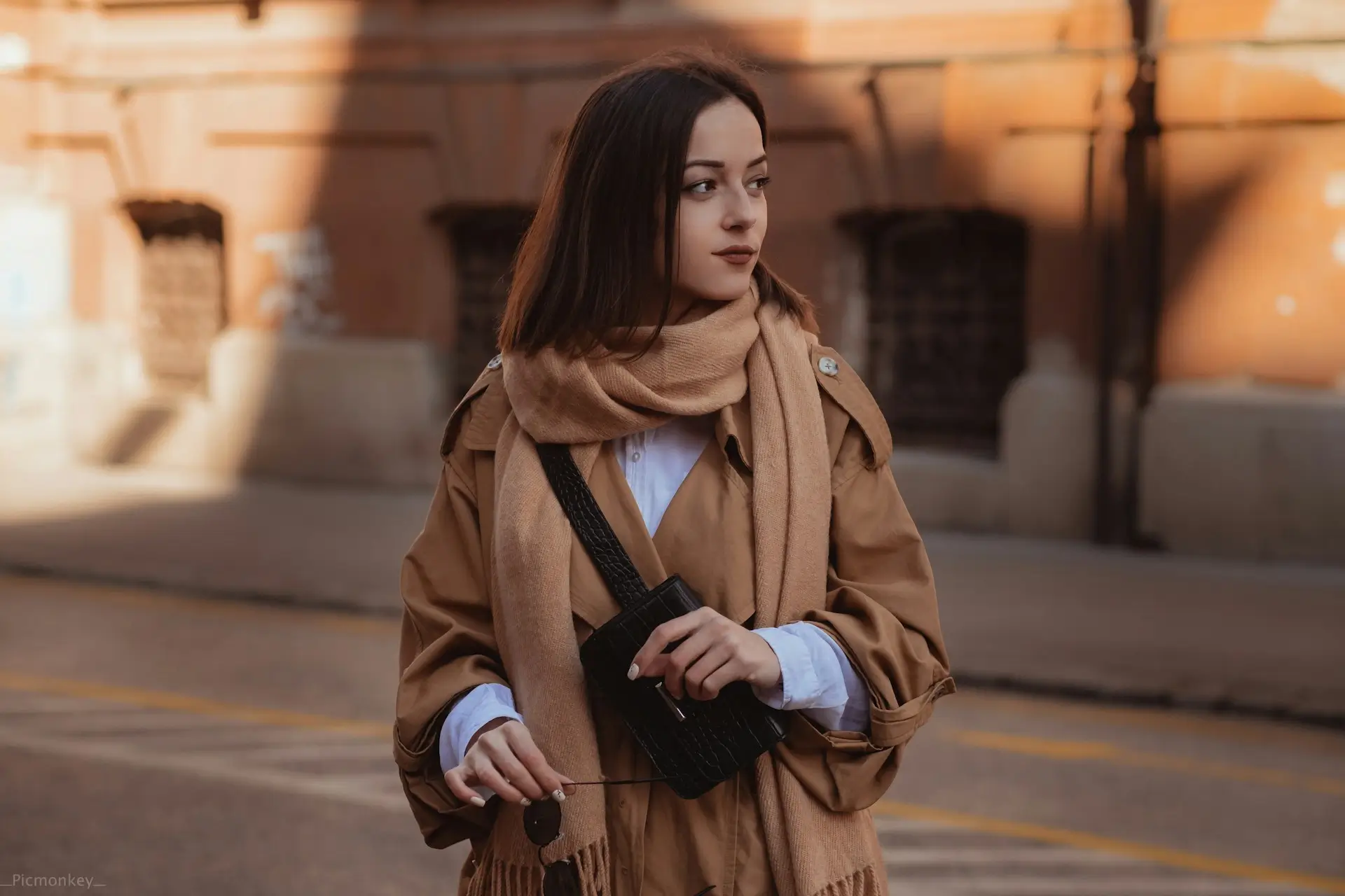 Mujer con abrigo neutro y valija, look cómodo y elegante para viajar en invierno